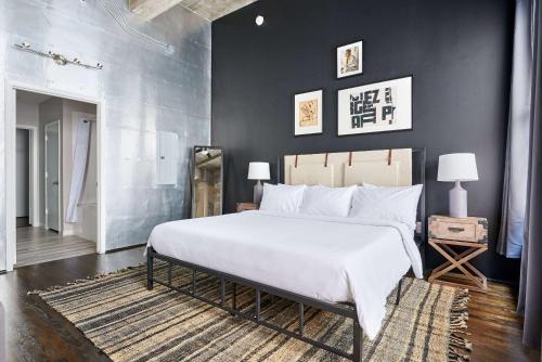 una camera da letto con un grande letto bianco e pareti nere di Reside Houston Downtown, a Wyndham Residence a Houston