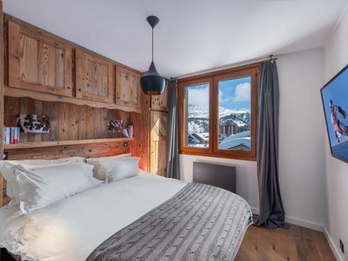 a bedroom with a large bed and a window at Appartement à Courchevel 1850, 3 chambres, casier à skis, à 80m des pistes - FR-1-564-96 in Courchevel