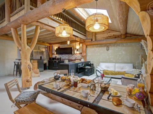 Il comprend un grand salon avec une table et une cuisine. dans l'établissement Gîte de charme avec poêle à bois, billard et terrasse dans les Monts du Forez - FR-1-496-313, à Saint-Jean-Soleymieux