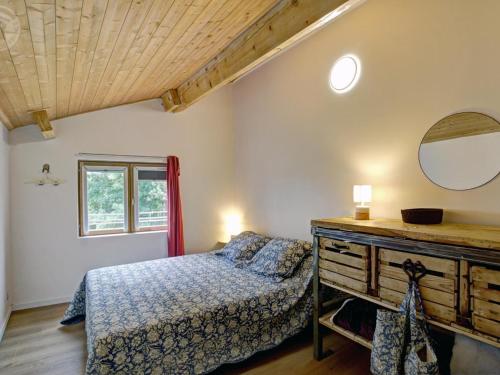 una camera da letto con un letto e un comò con uno specchio di Gîte de charme avec poêle à bois, billard et terrasse dans les Monts du Forez - FR-1-496-313 a Saint-Jean-Soleymieux