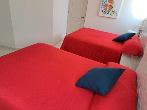 two red beds with blue pillows in a room at Hotel Anturio in Dolores Hidalgo