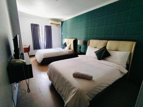 a bedroom with two beds and a television in it at LOHAS Airport Hotel and Restaurant in Cagayan de Oro