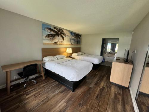 a hotel room with two beds and a desk and a computer at Rodeway Inn in Owensboro