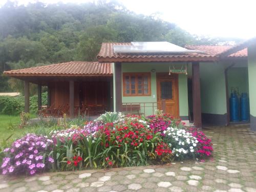 uma pequena casa com flores em frente em Verde Mauá Chales em Viscode de Mauá
