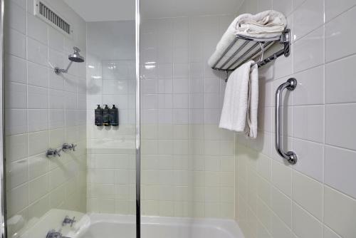 a bathroom with a shower and a tub and a sink at Mercure Perth On Hay in Perth