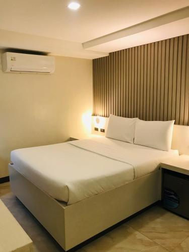 a bedroom with a large bed with white pillows at Oyster Plaza Hotel in Manila