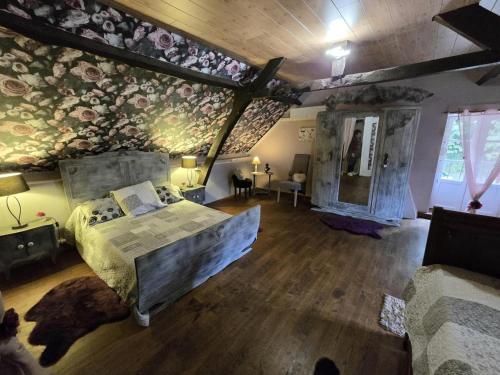 une chambre avec un grand lit dans une pièce avec parquet dans l'établissement Maison familiale avec grand jardin, proche de Sarlat, cheminée, Wifi, animaux acceptés - FR-1-616-61, à Sainte-Mondane