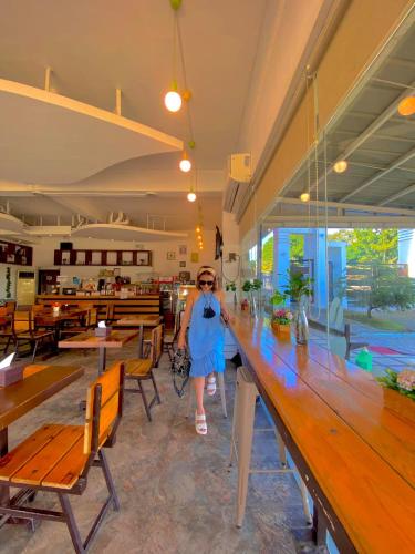 a woman standing at a long table in a restaurant at LOHAS Airport Hotel and Restaurant in Cagayan de Oro