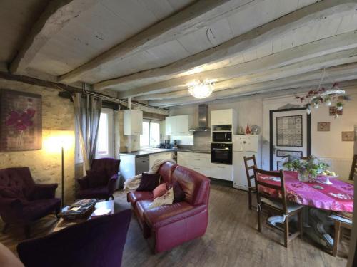 un salon avec un canapé et une table avec des chaises dans l'établissement Maison Périgourdine avec Cheminée, Jardin Privé & Wifi, Proche Sarlat et Vallée de la Dordogne - FR-1-616-49, à Sainte-Mondane