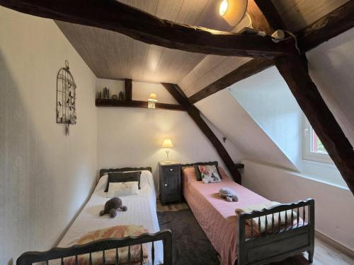 une chambre mansardée avec deux lits dans un grenier dans l'établissement Maison Périgourdine avec Cheminée, Jardin Privé & Wifi, Proche Sarlat et Vallée de la Dordogne - FR-1-616-49, à Sainte-Mondane