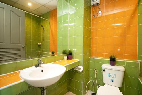 a bathroom with a sink and a toilet and a mirror at 181 Ekkamai Apartment in Bangkok