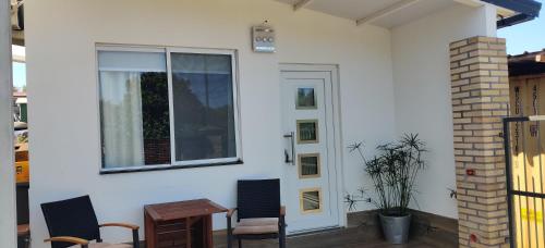 a patio with chairs and a table and a window at Casa Nathan! 2 Zimmer, Internet, Küche, Cosina, Parking, Lavanderia, Sauna! Barrio Esperanza! Central! in Hohenau