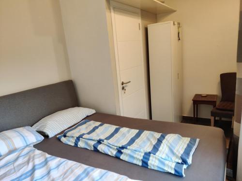 a bed with a blue and white striped blanket on it at Casa Nathan! 2 Zimmer, Internet, Küche, Cosina, Parking, Lavanderia, Sauna! Barrio Esperanza! Central! in Hohenau