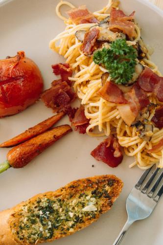 奥南海滩The Pin Boutique Pool Villa Krabi的一盘有意大利面、肉和叉子的食物