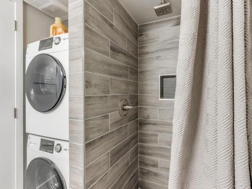 a bathroom with a washing machine in a shower at Quiet Modern Heavenly Paradise Love and Balcony Near Lake, Mall, Food, Entertainment! in Oklahoma City