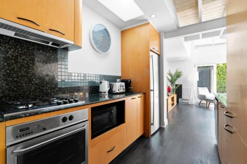 a kitchen with wooden cabinets and a stove top oven at Port Paradiso in Melbourne