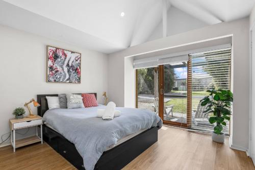 a bedroom with a bed and a large window at Otway Vista Five in Apollo Bay