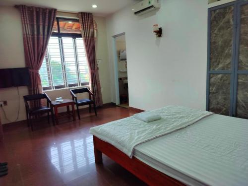 a bedroom with a bed and a table and chairs at Nhật Linh Homestay in Hue