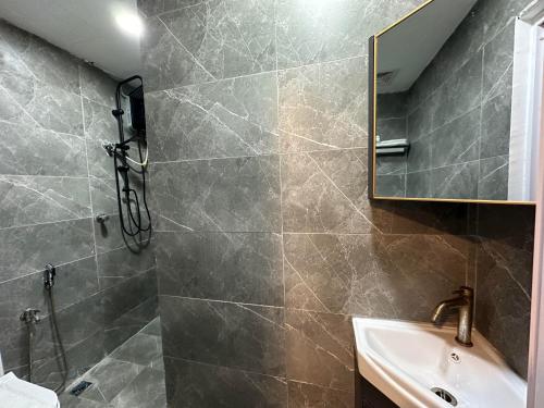 a bathroom with a shower and a sink and a mirror at SS Grey House in Kuala Lumpur