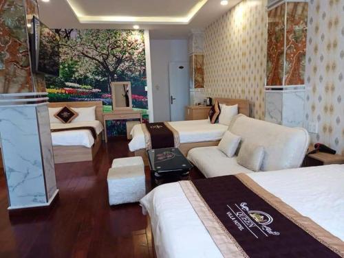 a hotel room with three beds and a couch at Queen Villa Hotel 2 DL - by BAY LUXURY in Da Thien