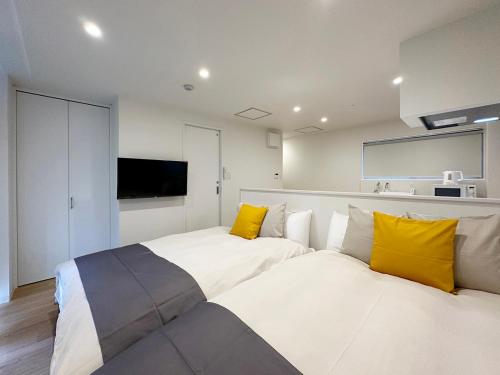 a bedroom with two large beds with yellow pillows at Hiroshima Hotel in Hiroshima