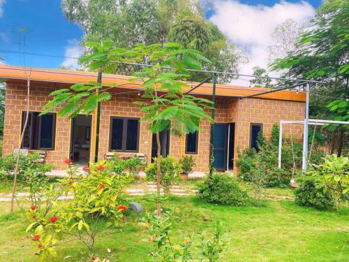 a brick house with a garden in front of it at Rafe Garden-Homestay Ba Vì in Ba Vì