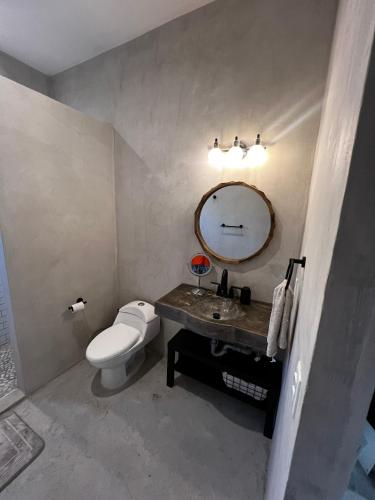 a bathroom with a toilet and a sink and a mirror at Ocean View, Gorgeous Rooftop, AC, Wifi & Peaceful in Todos Santos