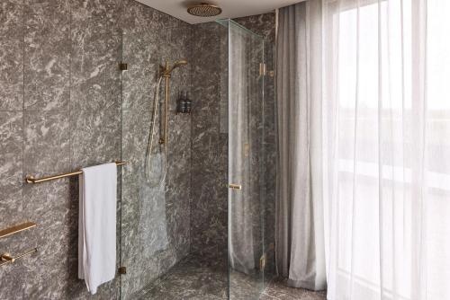 a bathroom with a shower with a glass door at Rydges Ringwood in Ringwood