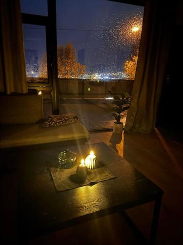 a candle on a table in a room with a window at Gammelgårdvegen 31 in Tromsø