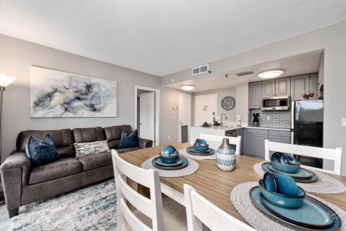 a living room with a dining room table and a couch at Apartment with Volcano Bay view in Orlando