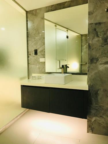 a bathroom with a sink and a mirror at Oyster Plaza Hotel in Manila