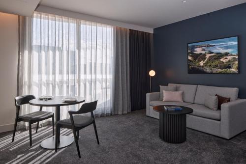 a living room with a couch and a table at Rydges Ringwood in Ringwood