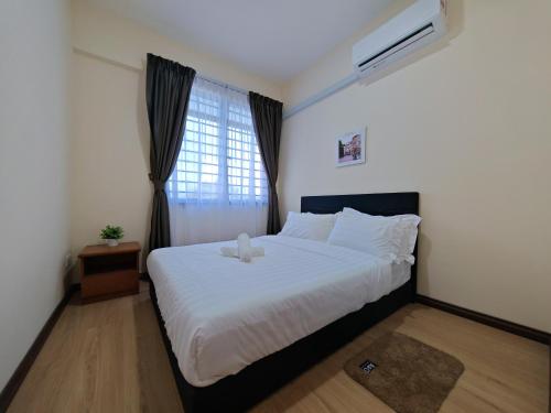 a bedroom with a bed with a teddy bear on it at Riverside Landed House 河景湾 in Kota Kinabalu