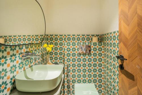 a bathroom with a tub and a toilet and a sink at ELIVAAS 1 BHK with Rooftop Pool - Kamerios Verano in Goa