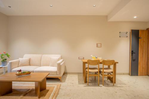 a living room with a couch and a table at ELIVAAS 1 BHK with Rooftop Pool - Kamerios Verano in Goa