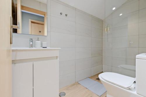 a white bathroom with a toilet and a sink at Lovely studio fully equipped near subway N11 - Shared bathroom with another Studio in Lisbon