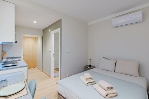 a bedroom with a white bed with towels on it at Lovely studio fully equipped near subway N8 in Lisbon