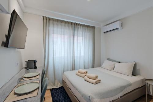 a bedroom with a bed with two towels on it at Lovely studio fully equipped near subway N4 in Lisbon