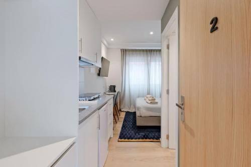 a hallway leading to a bedroom with a bed at Lovely studio fully equipped near subway N4 in Lisbon
