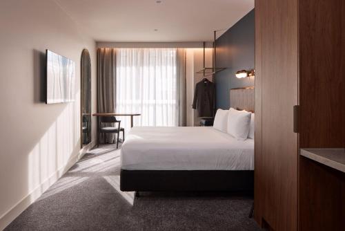 a hotel room with a bed and a table at Rydges Ringwood in Ringwood