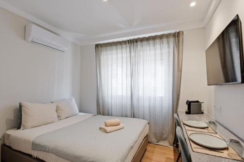 a bedroom with a bed with two towels on it at Lovely studio fully equipped near subway N13 in Lisbon
