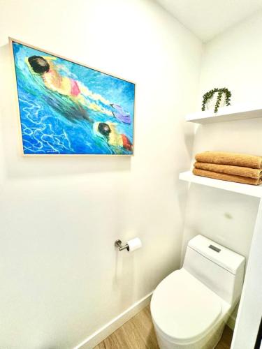 a bathroom with a toilet and a painting on the wall at Modern Home with private beach on St. Croix River in Lakeland