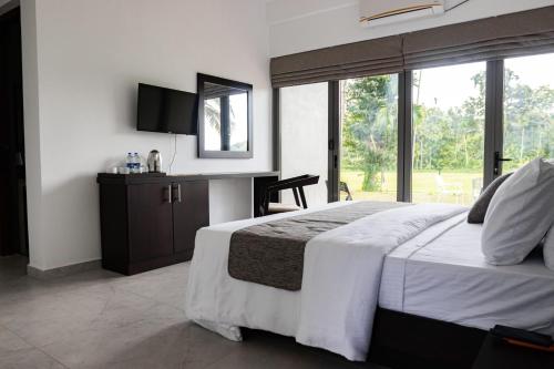a bedroom with a bed and a desk with a mirror at Paddy View Garden Resort in Narammala