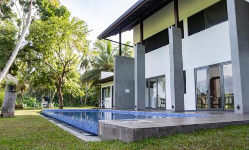 a house with a swimming pool in front of it at Paddy View Garden Resort in Narammala