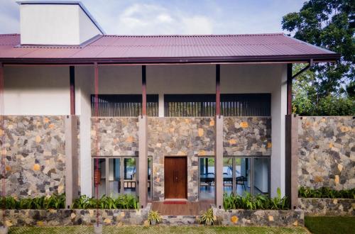 a house with a stone wall at Paddy View Garden Resort in Narammala