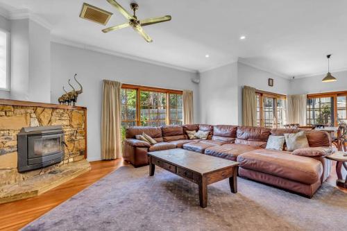 a living room with a couch and a fireplace at Heart Of Long Point in Merimbula