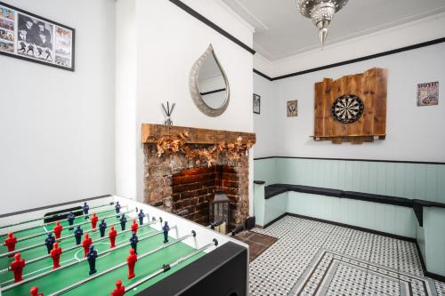 a room with a foosball table and a fireplace at Swiss Haven - Spacious 3 Bedroom House in Liverpool