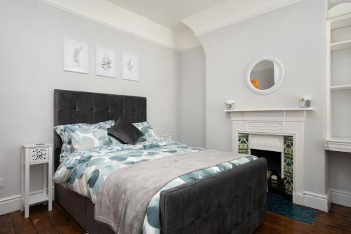 a bedroom with a large bed and a fireplace at Swiss Haven - Spacious 3 Bedroom House in Liverpool