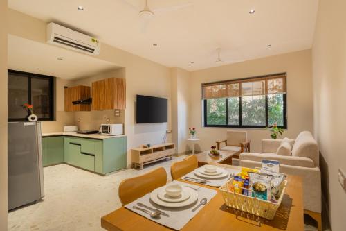a kitchen and a living room with a table and chairs at ELIVAAS 1 BHK with Jacuzzi & Lift - Kamerios Brisa in Goa