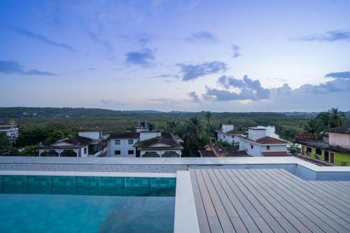 a swimming pool with a view of a city at ELIVAAS 1 BHK with Jacuzzi & Lift - Kamerios Brisa in Goa